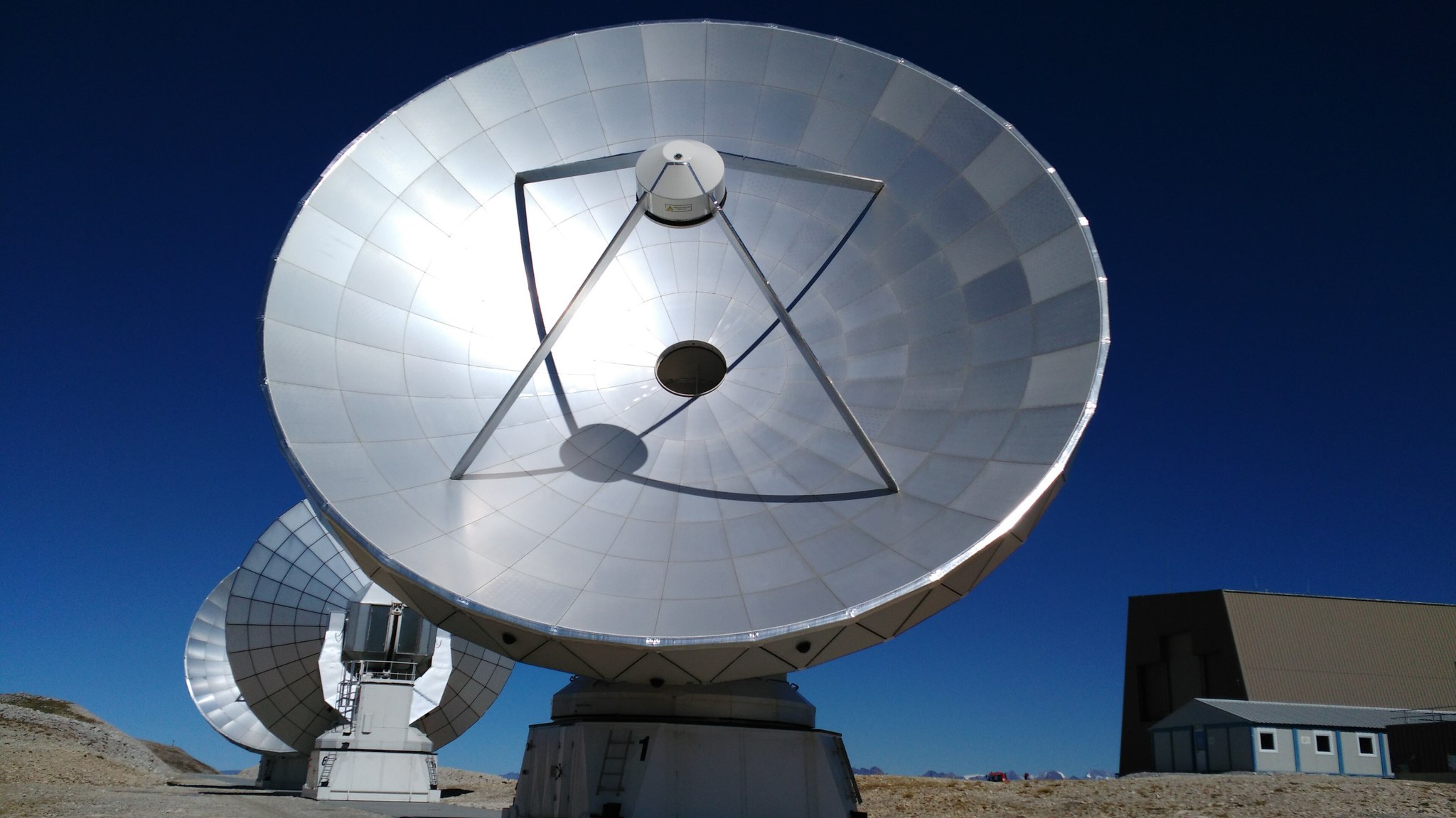Radio telescope dishes under blue sky, full size