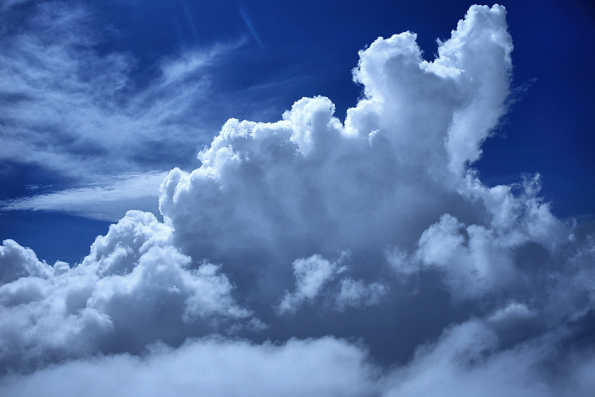 Billowing cumulus clouds in blue sky, full size