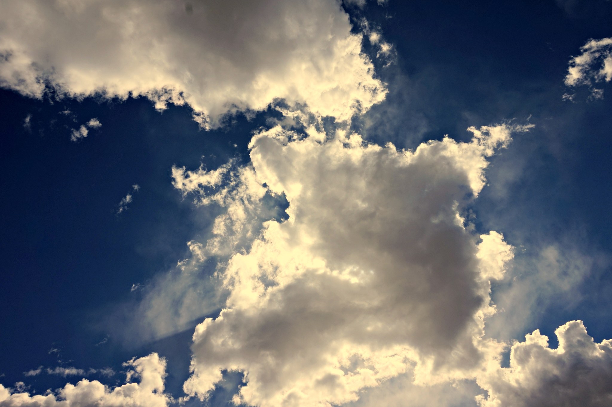 Sunlit clouds in deep blue sky, full size